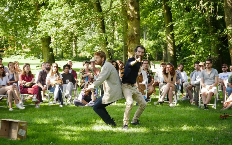Deux conteurs en représentation dans un parc devant des spectateurs