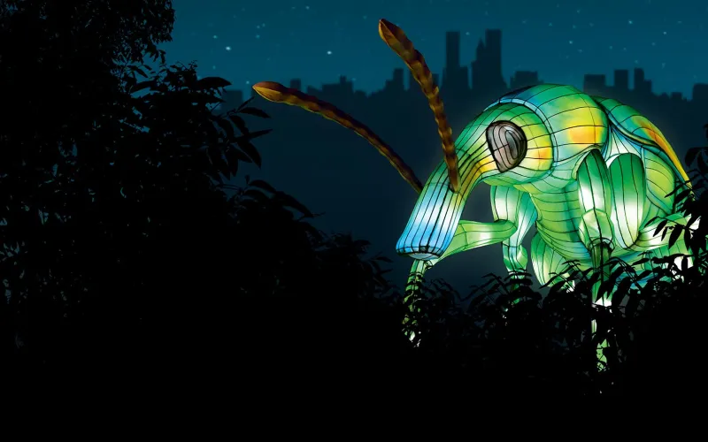 Installation lumineuse géante en forme d'insecte vert.