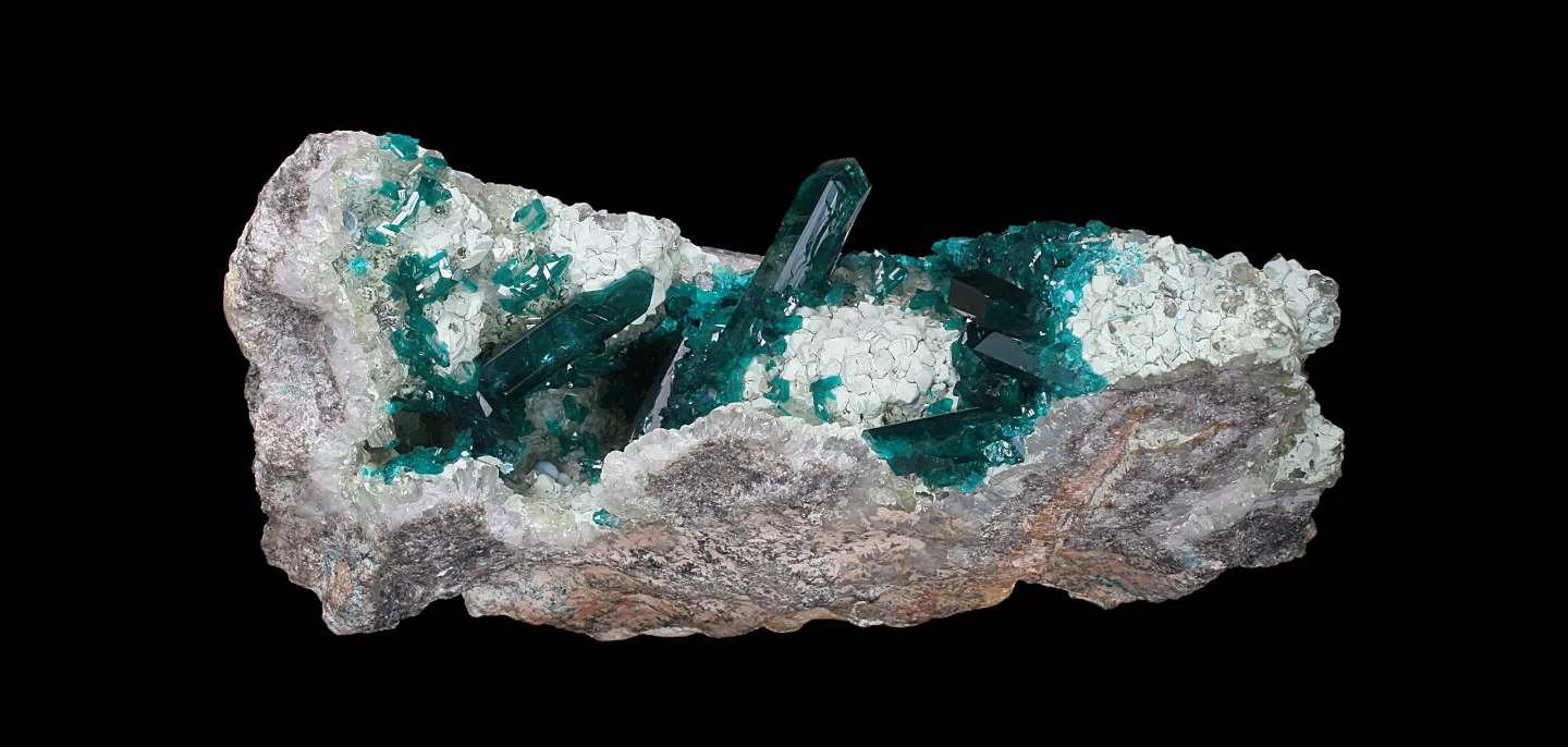 Assemblage de cristaux prismatiques vert profond de Dioptase sur du Quartz (N° 108.1747) © MNHN - L.-D. Bayle Assemblage de cristaux prismatiques vert profond de Dioptase sur du Quartz sur fond noir